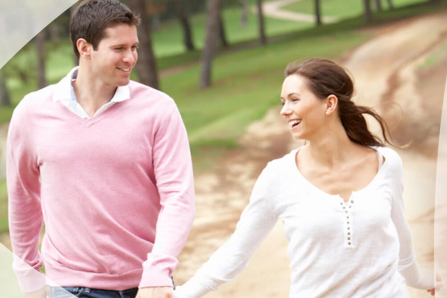 Couple heureux tenant la main et la marche dans le parc