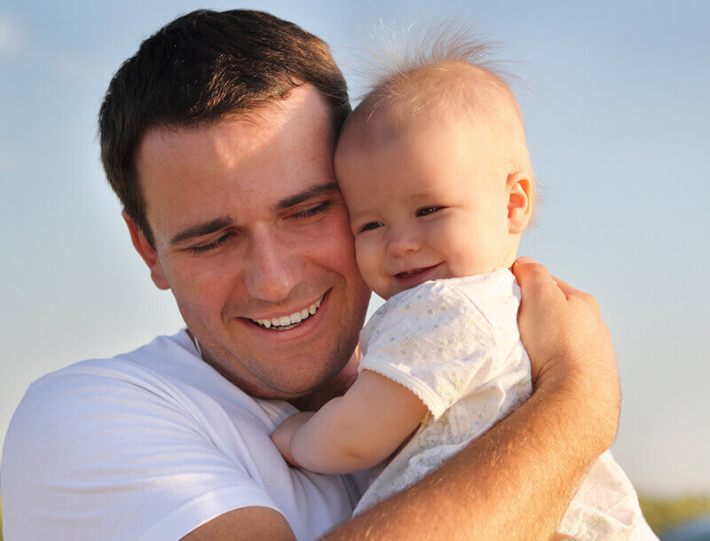Père souriant et serrant un bébé