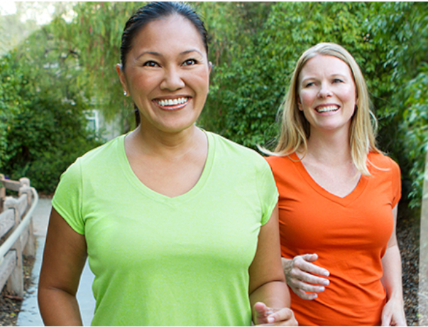 Deux femmes actives, en santé et souriantes qui marchent.
